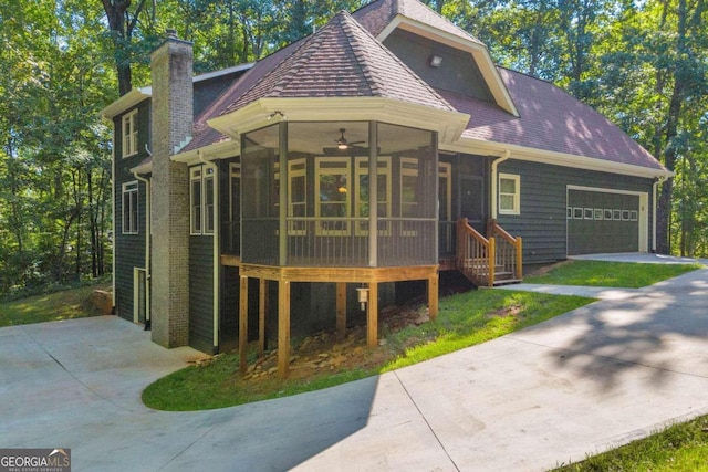 exterior space featuring a garage, ceiling fan, and a sunroom