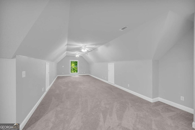 bonus room with lofted ceiling, light carpet, and ceiling fan