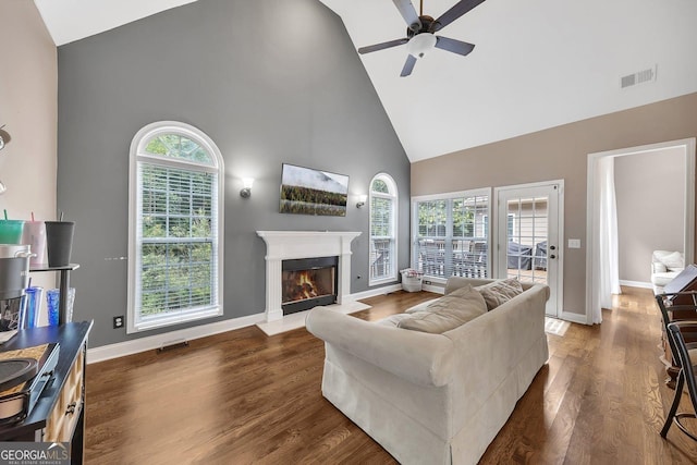 living room with ceiling fan, dark hardwood / wood-style flooring, and high vaulted ceiling