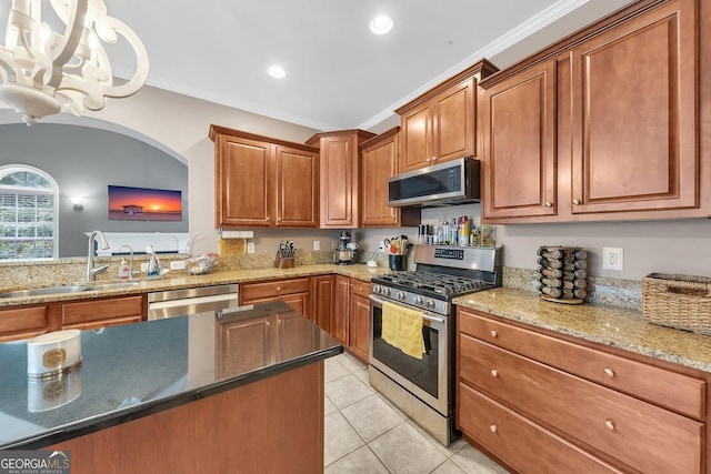 kitchen featuring sink, ornamental molding, light tile patterned floors, stainless steel appliances, and light stone countertops