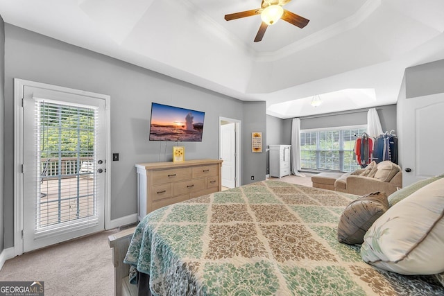 carpeted bedroom featuring ceiling fan, a raised ceiling, multiple windows, and access to outside