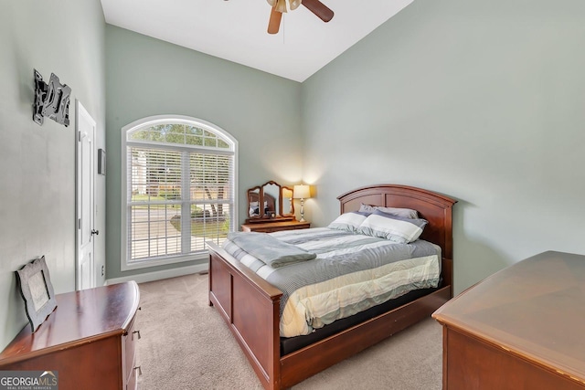 bedroom featuring ceiling fan, high vaulted ceiling, and light carpet