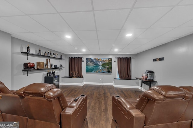 home theater featuring dark hardwood / wood-style flooring and a drop ceiling