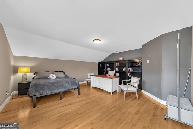 bedroom with vaulted ceiling and light hardwood / wood-style floors