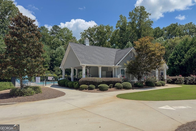 view of property's community featuring a swimming pool and a lawn