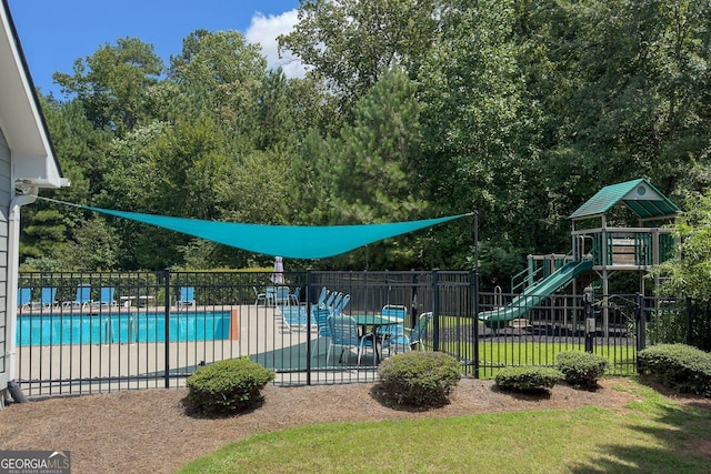 view of swimming pool featuring a playground and a patio