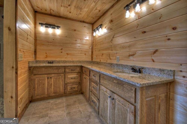 bathroom with tile patterned floors, wooden walls, vanity, and wooden ceiling