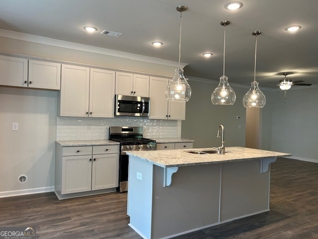 kitchen with sink, ceiling fan, an island with sink, light stone countertops, and appliances with stainless steel finishes