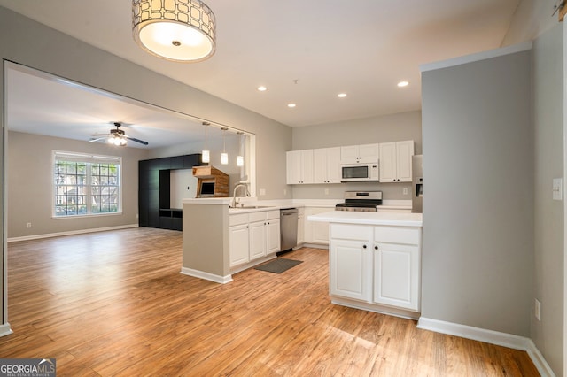 kitchen featuring appliances with stainless steel finishes, kitchen peninsula, white cabinets, and ceiling fan