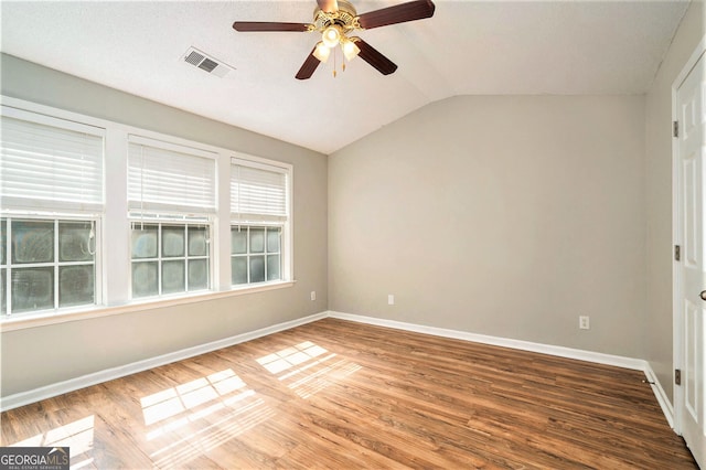 spare room with lofted ceiling, hardwood / wood-style floors, a textured ceiling, and ceiling fan