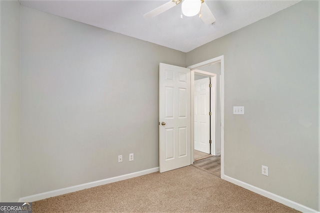 spare room with light colored carpet and ceiling fan