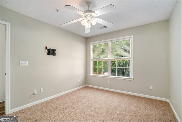 carpeted empty room with a textured ceiling and ceiling fan