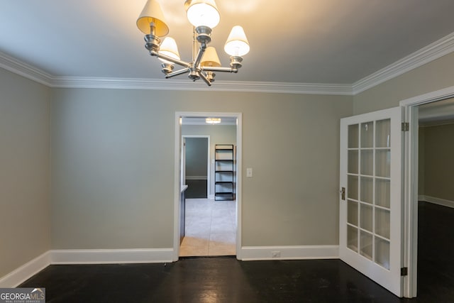 spare room with crown molding, hardwood / wood-style floors, and a chandelier