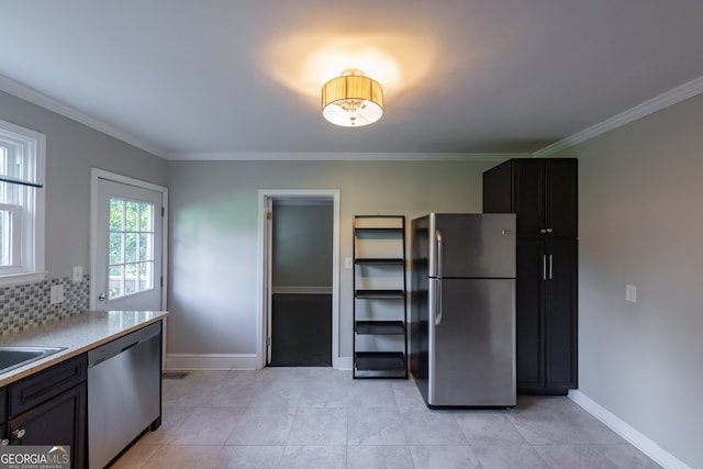 kitchen with appliances with stainless steel finishes, light tile patterned floors, decorative backsplash, and crown molding