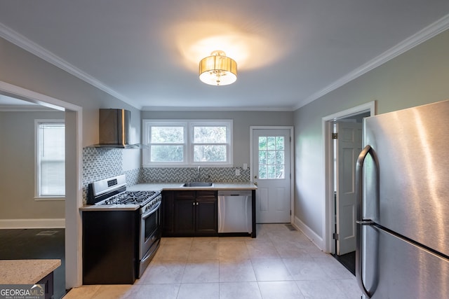 kitchen with backsplash, appliances with stainless steel finishes, ornamental molding, sink, and wall chimney range hood