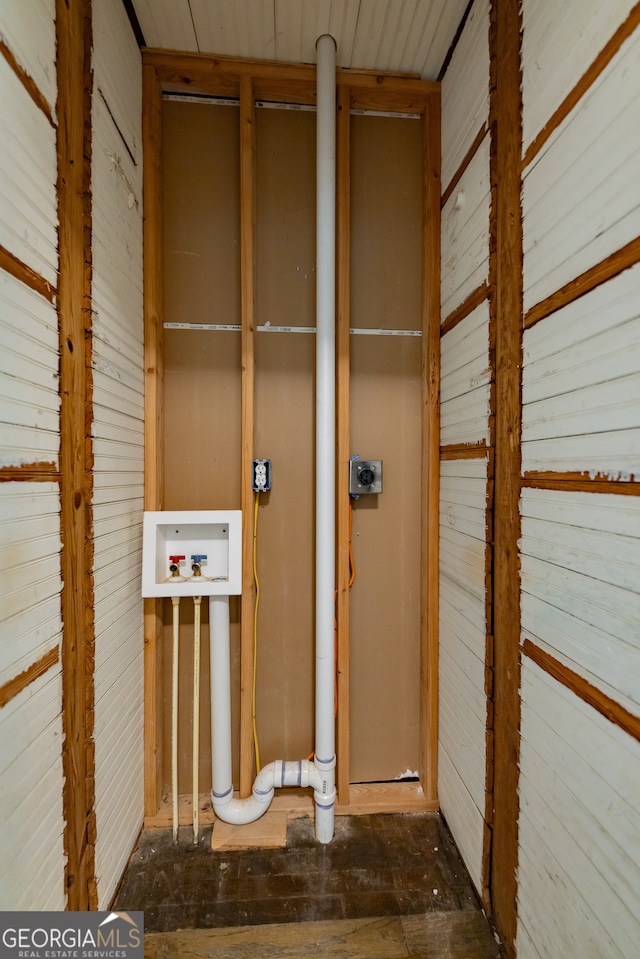 interior space with hookup for a washing machine, wood walls, and electric dryer hookup