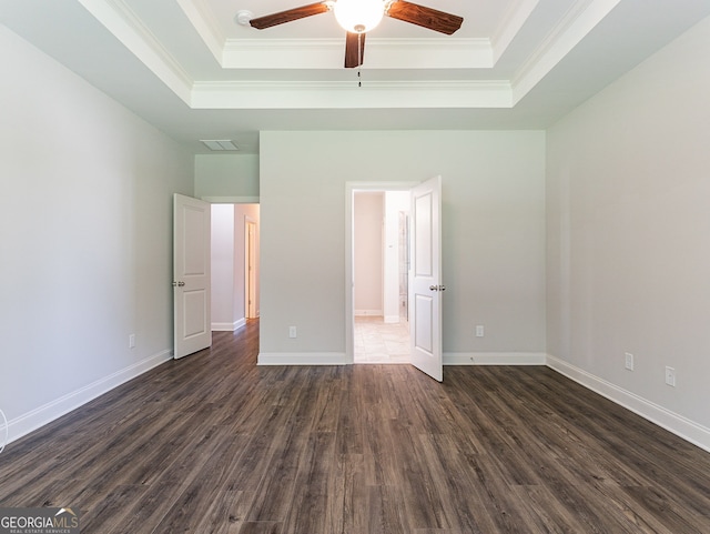 unfurnished bedroom featuring ceiling fan, wood-type flooring, and a raised ceiling