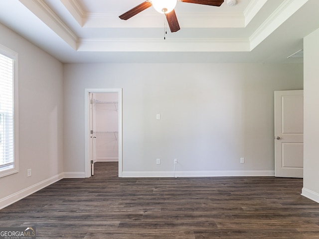 spare room featuring wood-type flooring, a tray ceiling, and a healthy amount of sunlight