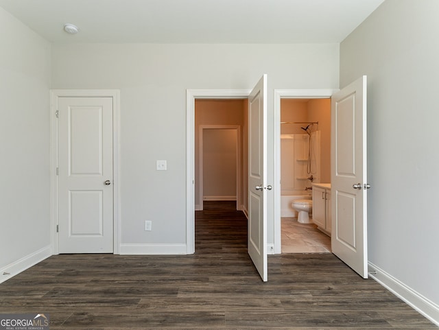 unfurnished bedroom featuring hardwood / wood-style floors and ensuite bathroom