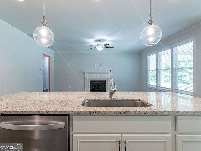 kitchen featuring ceiling fan, a fireplace, ornamental molding, and light stone countertops