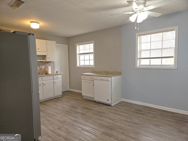 kitchen with stainless steel refrigerator, white cabinetry, ceiling fan, light wood-type flooring, and dishwasher