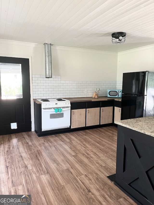 kitchen with tasteful backsplash, white electric range oven, black fridge, ornamental molding, and wood-type flooring