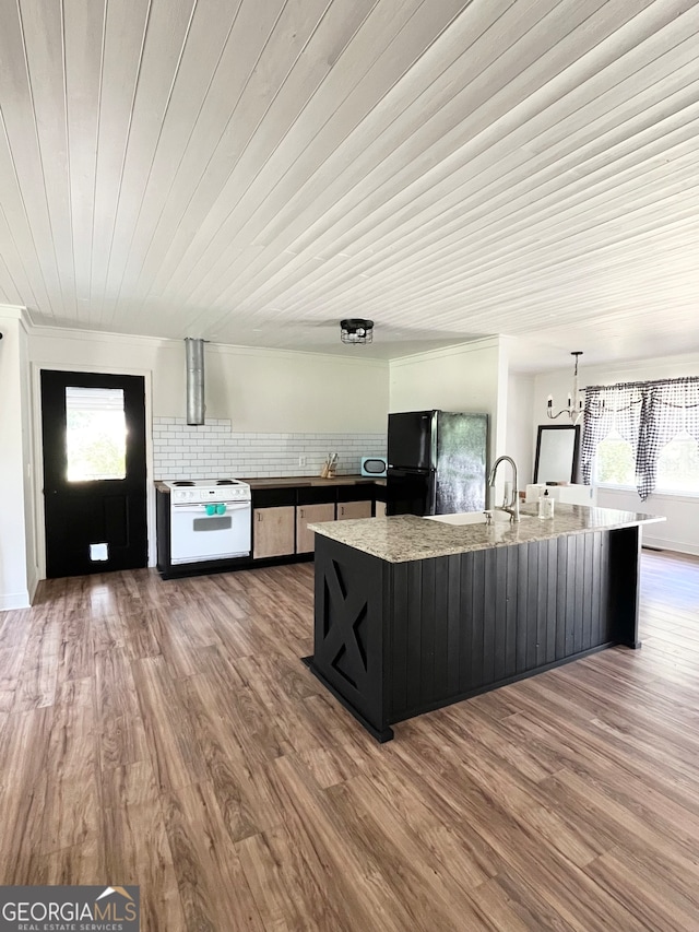 kitchen with decorative backsplash, black refrigerator, white electric stove, and hardwood / wood-style flooring