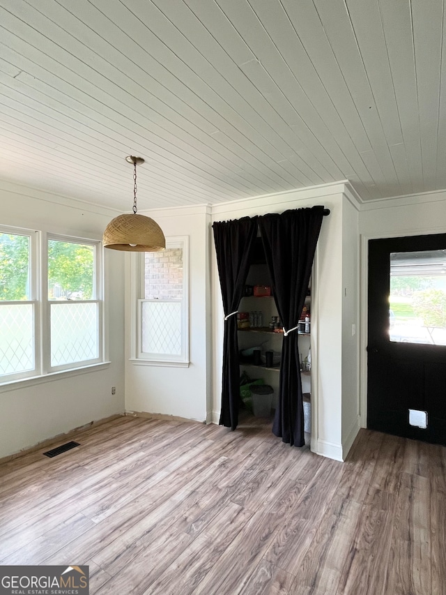 unfurnished living room featuring wooden ceiling, ornamental molding, and hardwood / wood-style floors