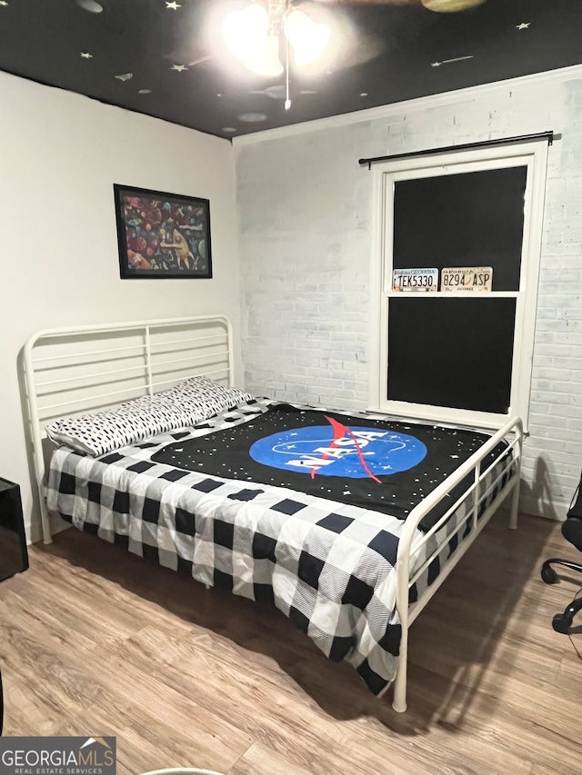 bedroom featuring ceiling fan, crown molding, and hardwood / wood-style flooring