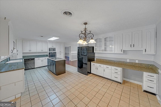 kitchen featuring light tile patterned floors, stainless steel microwave, dishwashing machine, oven, and black refrigerator