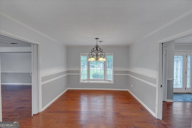 unfurnished dining area featuring a notable chandelier, a textured ceiling, hardwood / wood-style floors, and crown molding