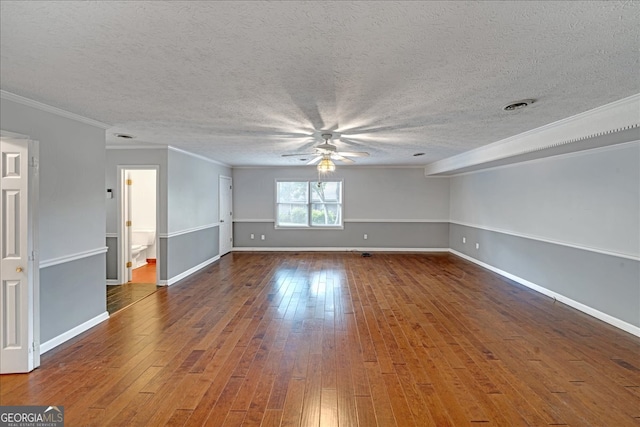 empty room featuring wood-type flooring, a textured ceiling, and ornamental molding