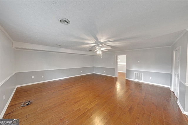 spare room featuring hardwood / wood-style floors, crown molding, and a textured ceiling