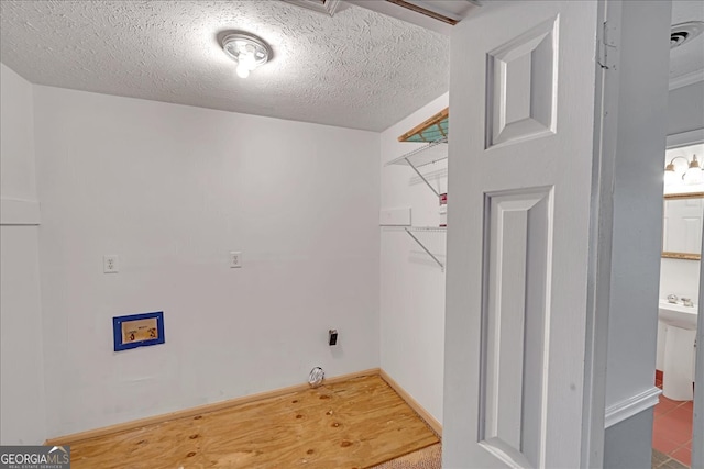 laundry area with a textured ceiling and tile patterned flooring