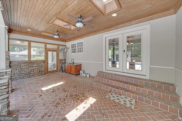 interior space featuring ceiling fan, wood ceiling, and a wealth of natural light