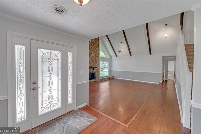 foyer entrance featuring a textured ceiling, lofted ceiling with beams, and hardwood / wood-style flooring