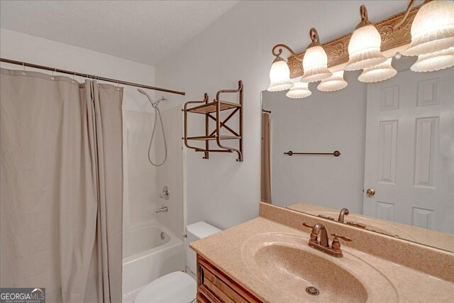 full bathroom featuring a textured ceiling, toilet, shower / tub combo with curtain, and vanity