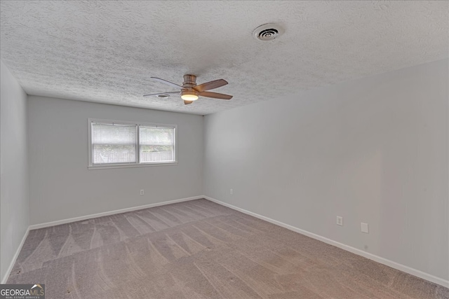 spare room featuring a textured ceiling, ceiling fan, and carpet floors