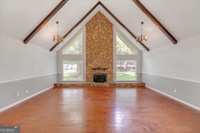 unfurnished living room with an inviting chandelier, hardwood / wood-style flooring, a fireplace, and beam ceiling