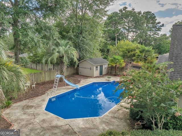 view of swimming pool featuring a water slide and a shed