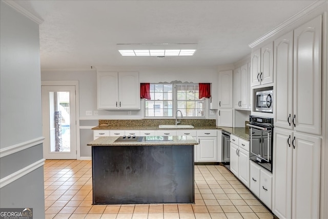 kitchen with light tile patterned flooring, white cabinetry, a center island, black appliances, and sink