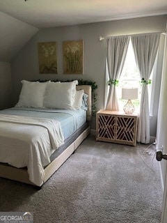 bedroom featuring lofted ceiling and light carpet