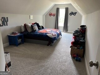 bedroom with vaulted ceiling and carpet floors