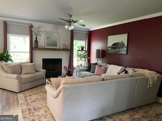 living room with ceiling fan, wood-type flooring, and ornamental molding