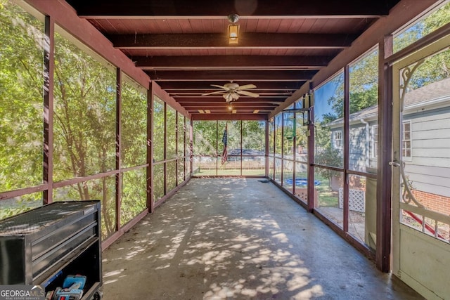 unfurnished sunroom featuring beam ceiling and wood ceiling