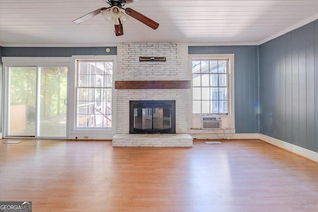 unfurnished living room with a ceiling fan, crown molding, a fireplace, wood finished floors, and cooling unit