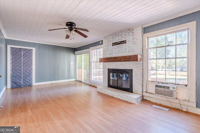 unfurnished living room featuring light hardwood / wood-style floors, a brick fireplace, a healthy amount of sunlight, and wood ceiling