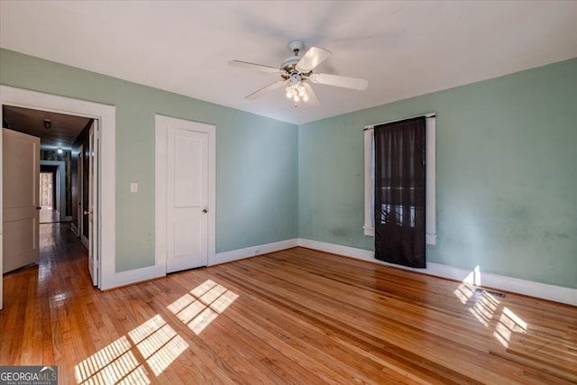 empty room with light hardwood / wood-style floors and ceiling fan