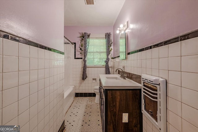 full bathroom featuring toilet, tile walls, heating unit, vanity, and tile patterned flooring