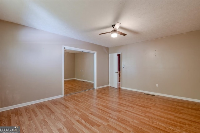 unfurnished room with ceiling fan, a textured ceiling, and light hardwood / wood-style flooring